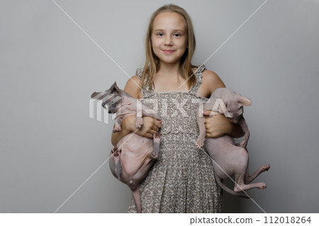 Happy girl kid with two cat against gray studio wall banner background 112018264