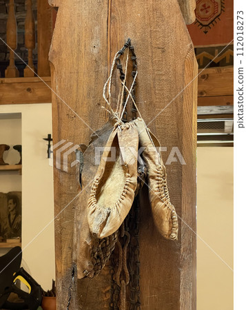 Old white leater woman shoes hanging on the wall Old white leater woman shoes hanging on the wall 112018273