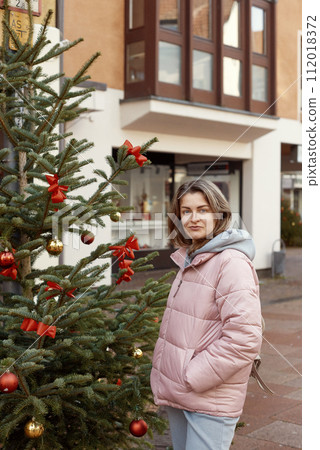 European Elegance: Christmas in Bietigheim-Bissingen. A beautiful girl stands on the street of the old European town of Bietigheim-Bissingen in Germany on Christmas Eve. City streets are decorated European Elegance: Christmas in Bietigheim-Bissingen. A beautiful girl stands on the street of the old European town of Bietigheim-Bissingen in Germany on Christmas Eve. City streets are decorated 112018372