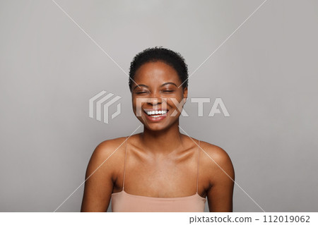 Laughing healthy young woman with dark shiny skin smiling looking at camera on white background.  112019062