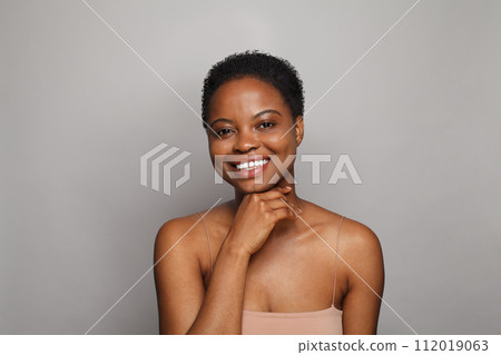 Cheerful healthy young woman with dark shiny skin smiling looking at camera on white background.  112019063