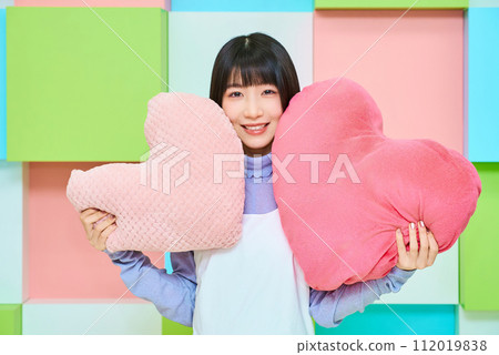 拿著心形墊子的年輕女子 拿著心形墊子的年輕女子 112019838