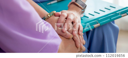 Closeup hands caregiver woman or doctor sitting on sofa encourage and care senior. Closeup hands caregiver woman or doctor sitting on sofa encourage and care senior. 112019856