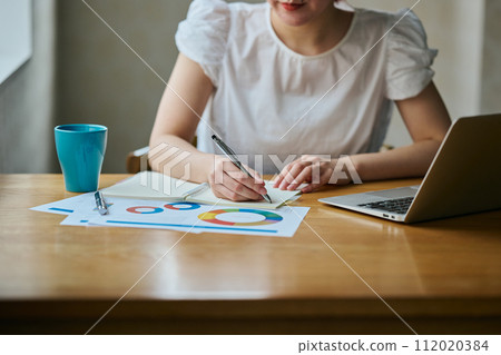 Young woman taking notes in a notebook Young woman taking notes in a notebook 112020384