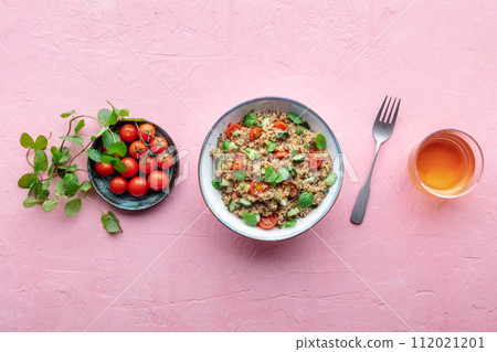 Quinoa tabbouleh salad in a bowl, a healthy dinner with tomatoes and mint Quinoa tabbouleh salad in a bowl, a healthy dinner with tomatoes and mint 112021201