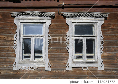A fragment of the wooden wall of an old house with white platbands in Rostov the Great A fragment of the wooden wall of an old house with white platbands in Rostov the Great 112021772