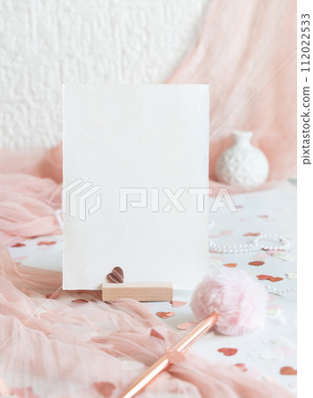 Vertical card near pink decorations, pen, hearts and tulle on white table close up, mockup 112022533