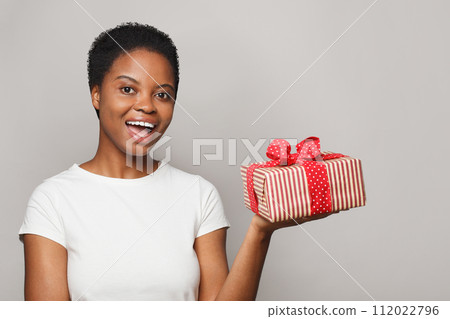 Surprised healthy woman holds colorful gift present box on white background. Surprised healthy woman holds colorful gift present box on white background. 112022796