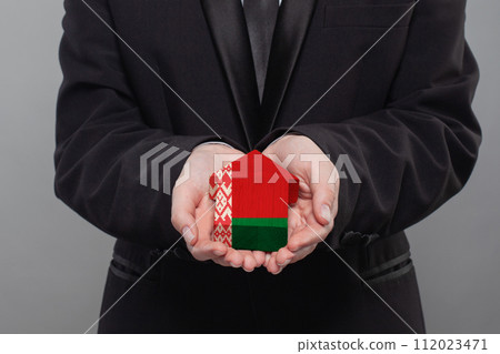 Belarussian person holding wooden house with flag of Belarus Finance, investment, mortgage 112023471