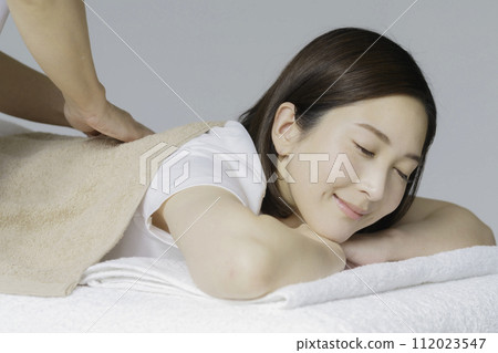 年輕女子接受背部按摩 年輕女子接受背部按摩 112023547