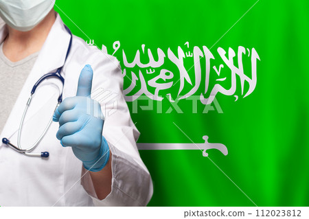 Saudi Arabian doctor's hand showing thumb up positive gesture on flag of Saudi Arabia background 112023812