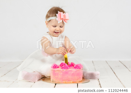 One year old child with a birthday cake. Beautiful baby on her first birthday.Baby with festive pastries and number 1 One year old child with a birthday cake. Beautiful baby on her first birthday.Baby with festive pastries and number 1 112024446