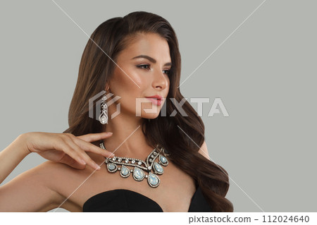 Attractive jewelry model woman with dark brown hair and shiny fresh skin wearing diamond earring Attractive jewelry model woman with dark brown hair and shiny fresh skin wearing diamond earring 112024640