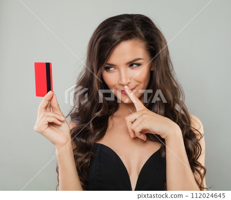 Glamorous joyful model brunette woman holding credit card looking at camera isolated  112024645