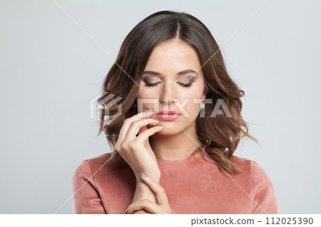 Cute female face closeup. Young brunette woman with makeup and natural healthy skin portrait 112025390