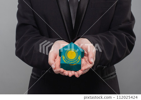 Kazakh person holding wooden house with flag of Kazakhstan Finance, investment, mortgage 112025424
