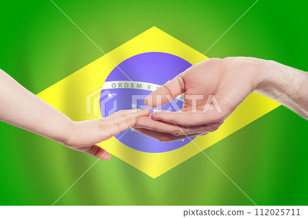 Brazilian baby and parent hands on the background of flag of Brazil Help, aid, support Brazilian baby and parent hands on the background of flag of Brazil Help, aid, support 112025711