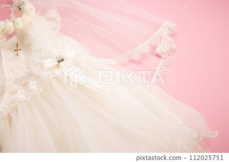 Baby baptism dress on pink background with cross and crown Baby baptism dress on pink background with cross and crown 112025751