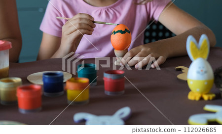 Little girl painting eggs for Easter in the kitchen, young family preparing for Easter celebration Little girl painting eggs for Easter in the kitchen, young family preparing for Easter celebration 112026685