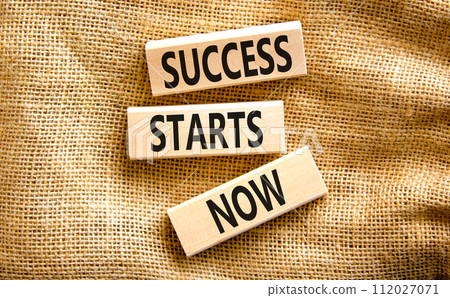 Success starts now symbol. Concept word Success starts now on beautiful wooden block. Beautiful canvas table canvas background. Business motivational success starts now concept. Copy space. 112027071