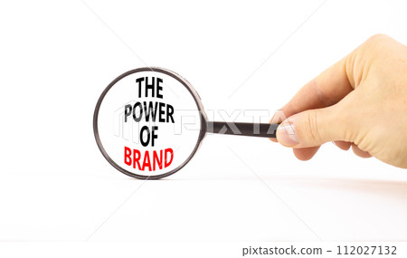 The power of brand symbol. Concept words The power of brand on beautiful magnifying glass. Beautiful white table white background. Businessman hand. Business the power of brand concept. Copy space. The power of brand symbol. Concept words The power of brand on beautiful magnifying glass. Beautiful white table white background. Businessman hand. Business the power of brand concept. Copy space. 112027132