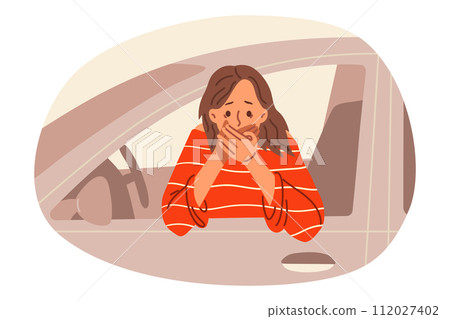 Woman driver suffers from nausea while driving, leans out of car and covers mouth with hand 112027402