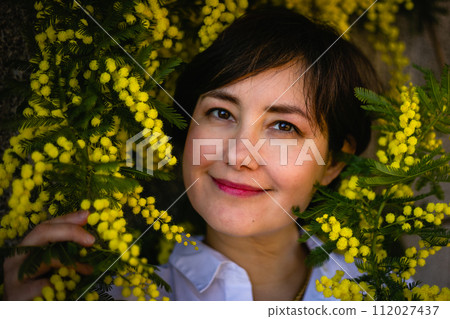 close up portrait of middle aged woman sitting under mimosa tree looking at camera close up portrait of middle aged woman sitting under mimosa tree looking at camera 112027437