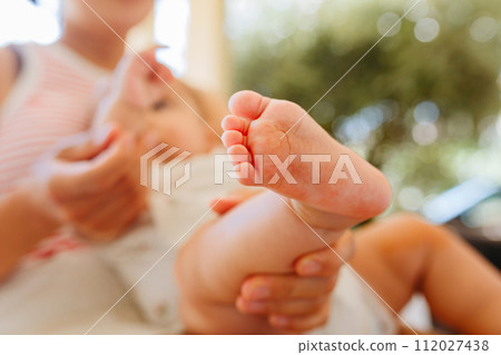 close up view of foot of new born baby held by mother close up view of foot of new born baby held by mother 112027438