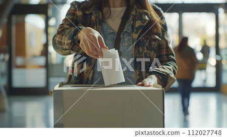 Close up of a young woman putting a package in a cardboard box 112027748
