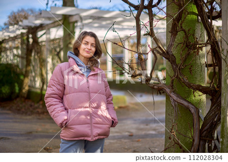Young beautiful pretty tourist girl in warm hat and coat with backpack walking at cold autumn in Europe city enjoying her travel in Bietigheim-Bissingen, Deutschland. Outdoor portrait of young tourist Young beautiful pretty tourist girl in warm hat and coat with backpack walking at cold autumn in Europe city enjoying her travel in Bietigheim-Bissingen, Deutschland. Outdoor portrait of young tourist 112028304