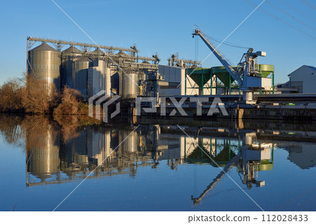 Riverside Manufacturing Twilight. Environmental Technology and Production. Riverside Manufacturing Hub. Eco-Friendly Technology and Production. industry and the environment, showcasing the integration 112028433