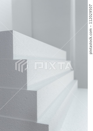 Close up of large panels of Styrofoam are stacked in a warehouse. 112029507