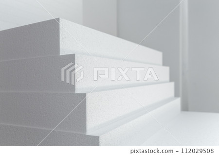 Close up of large panels of Styrofoam are stacked in a warehouse. 112029508