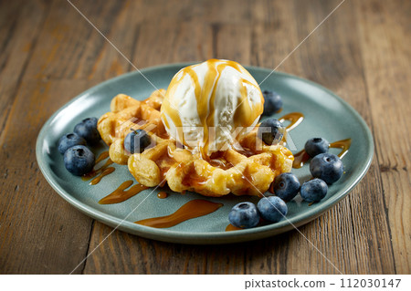 plate of belgian waffle with caramel sauce and blueberries plate of belgian waffle with caramel sauce and blueberries 112030147