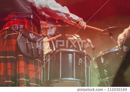 Close up of drummer's hands, of man in Scottish skirt. Holiday of St. Patrick's Day 112030189