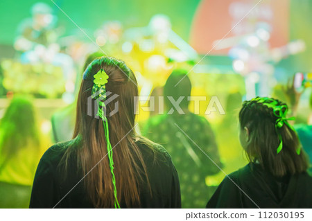 Rear view of girl green with clover decorations in hair. Saint Patrick's Day celebrating in club Rear view of girl green with clover decorations in hair. Saint Patrick's Day celebrating in club 112030195