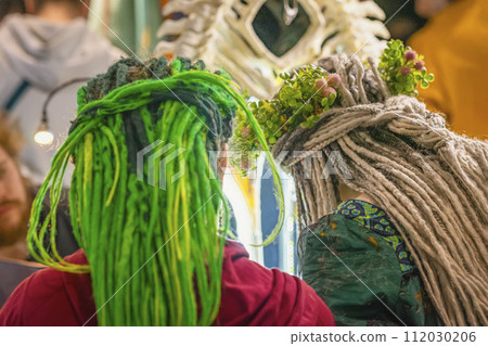 Back view of two girls with dreadlocks and clover wreaths on their heads. Saint Patrick's Day celebrating Back view of two girls with dreadlocks and clover wreaths on their heads. Saint Patrick's Day celebrating 112030206