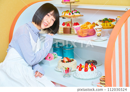 A young woman surrounded by sweets A young woman surrounded by sweets 112030324