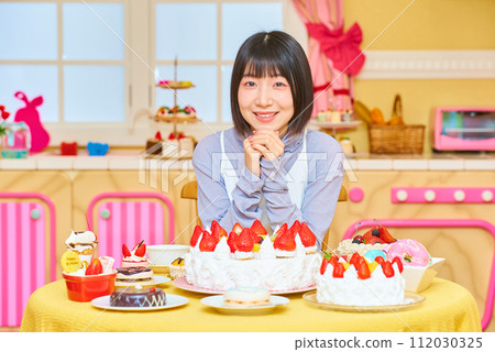 A young woman surrounded by sweets 112030325