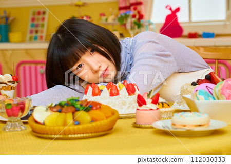 A young woman surrounded by sweets 112030333