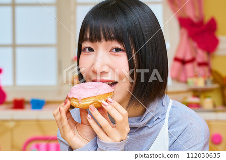 young woman holding a donut 112030635