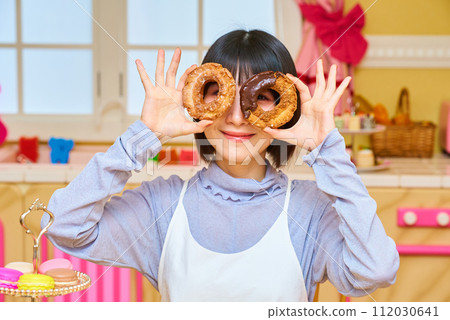 young woman holding a donut young woman holding a donut 112030641