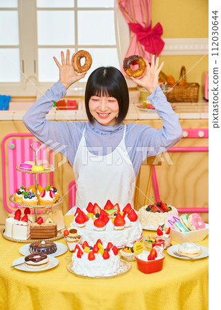 young woman holding a donut 112030644