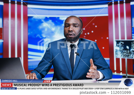 Reporter announces musical award winner on live television program, talking about talented artist and praising his music in newsroom. Media journalist hosting entertainment segment on newscast. 112031099