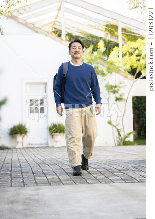 一名50多歲的男子肩上背著背包走路 112031221