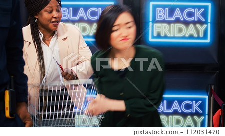 Aggressive clients start fight in store, black friday madness. People obsessed with shopping during seasonal sales event acting crazy after entering shopping center, crowd control. Aggressive clients start fight in store, black friday madness. People obsessed with shopping during seasonal sales event acting crazy after entering shopping center, crowd control. 112031470