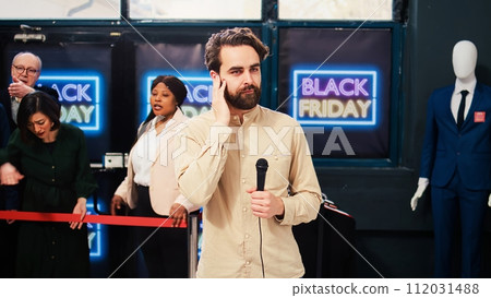 Journalist reporting live black friday madness from shopping center store. TV media reporter making news reportage in fashion boutique, filming aggressive mad crowd of shoppers. 112031488