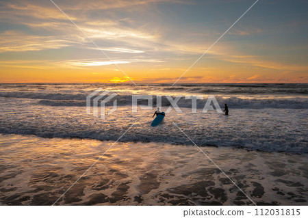 Surfer amateurs ride a board in the ocean at Surfer amateurs ride a board in the ocean at 112031815