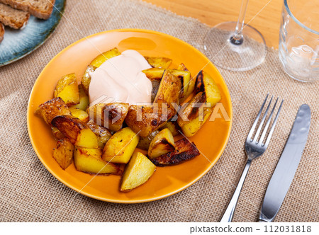 Spanish fried potatoes Patatas bravas served with cheese sauce 112031818