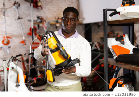 African-american man choosing drainline pump 112031986